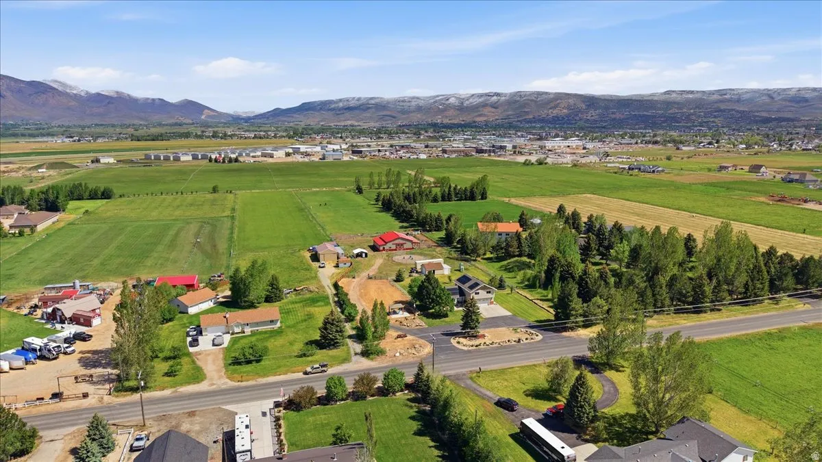 Aerial perspective showcasing expansive green fields and distant mountains