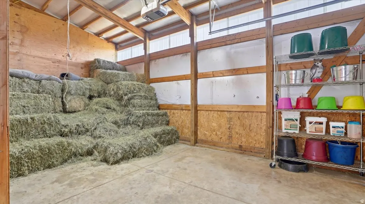 Spacious barn interior with exposed wooden beams, concrete flooring, and ample storage space