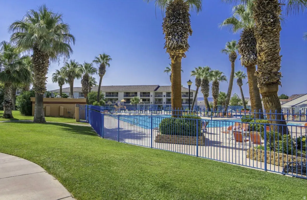 Outdoor swimming pool surrounded by a blue metal fence