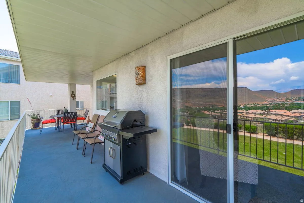 Covered outdoor patio area featuring a textured ceiling, stucco wall finish, and a sliding glass door