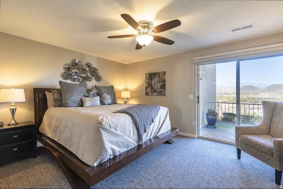 Bedroom featuring sliding glass door to exterior, carpeted flooring, and a ceiling fan with integrated lighting