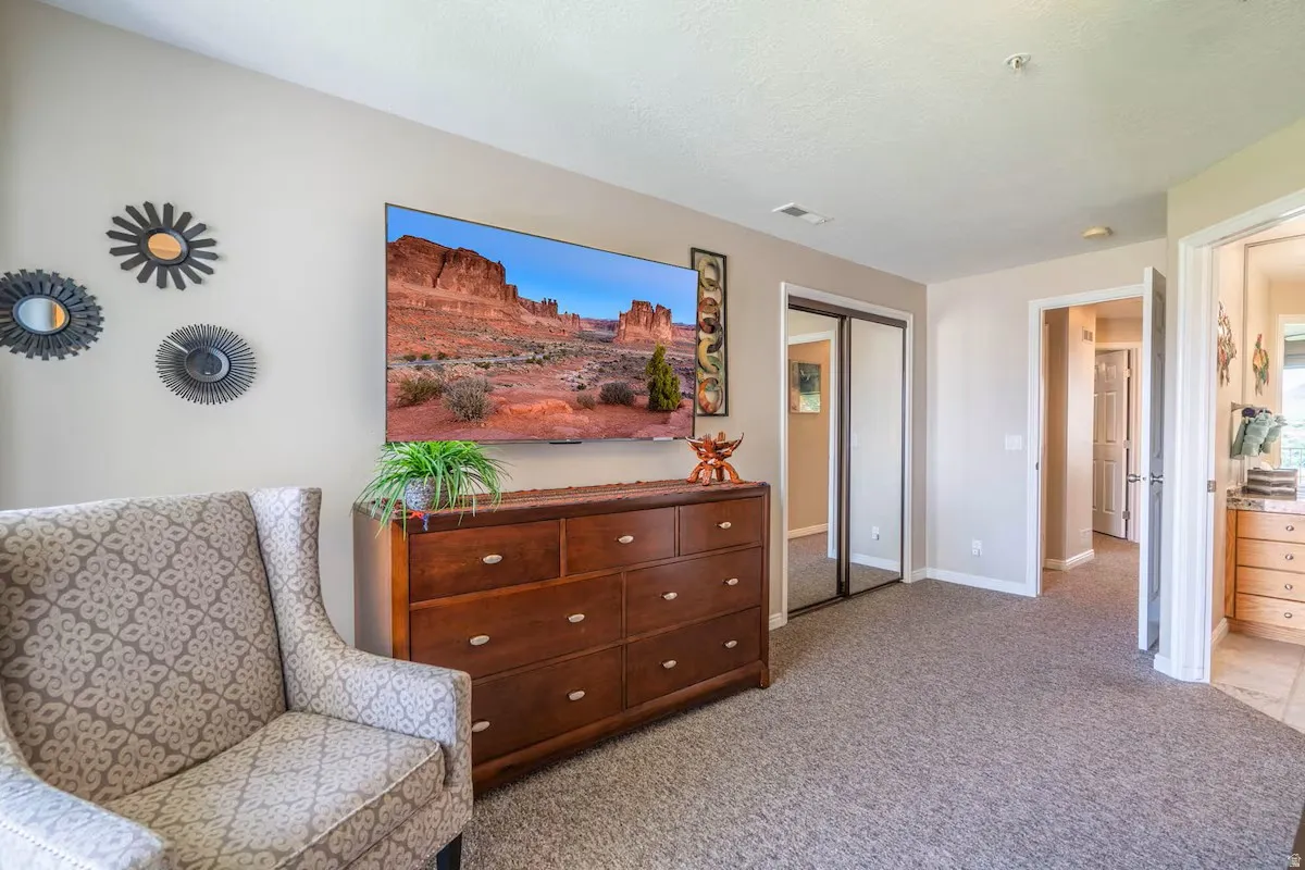 Carpeted interior space featuring a built-in closet with mirrored sliding doors, light-toned walls, and recessed lighting