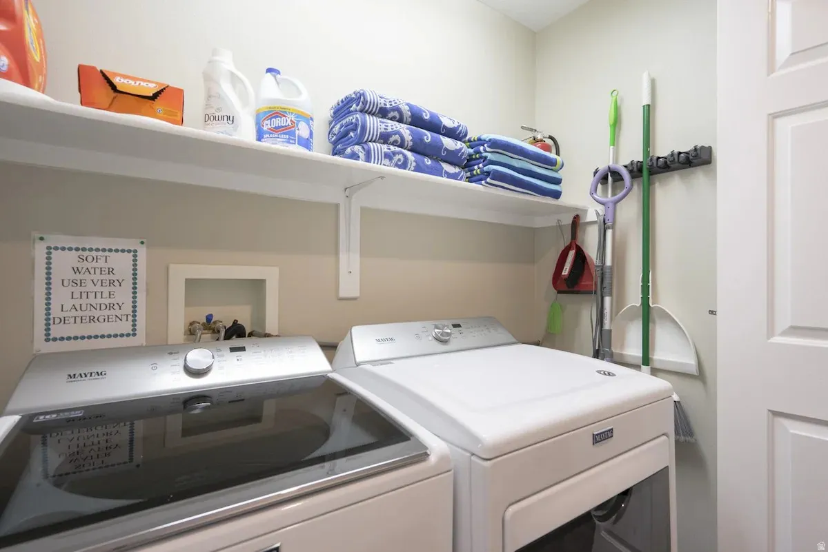 Dedicated laundry space featuring a white wall shelf, neutral wall paint, and a white paneled door