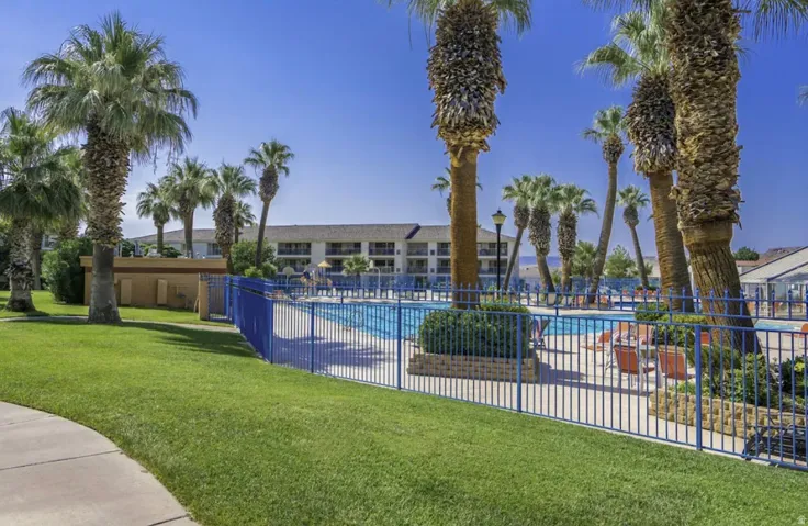 Outdoor swimming pool surrounded by a blue metal fence