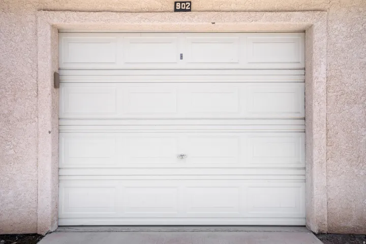 White paneled garage door framed by stucco exterior