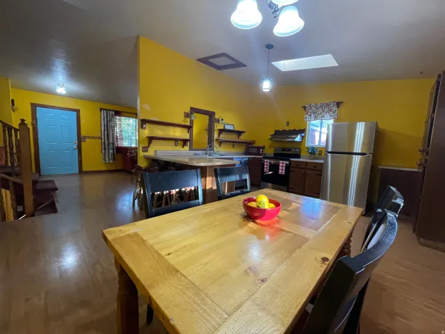 Kitchen featuring wood-finish flooring, stainless steel appliances, and a skylight