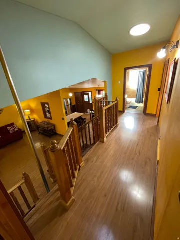 Second-story landing featuring wood-finish flooring and a wood railing system