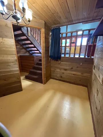 Staircase featuring wood railings and carpeted treads