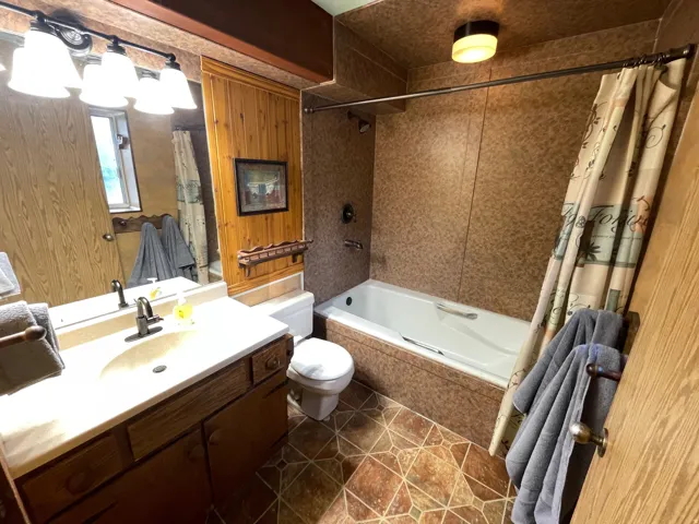 Bathroom featuring a vanity with an integrated sink, a rectangular mirror, and a four-light fixture
