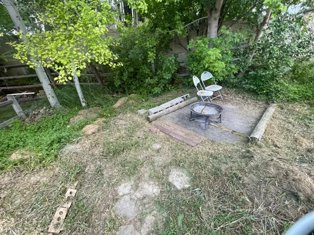 Outdoor gathering area featuring a central fire pit on a stone-look patio