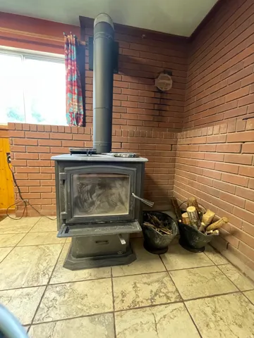 Wood-burning stove with a brick surround, featuring a tile floor
