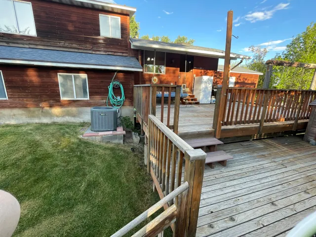 Expansive wood deck with railings and multiple levels, offering outdoor living space