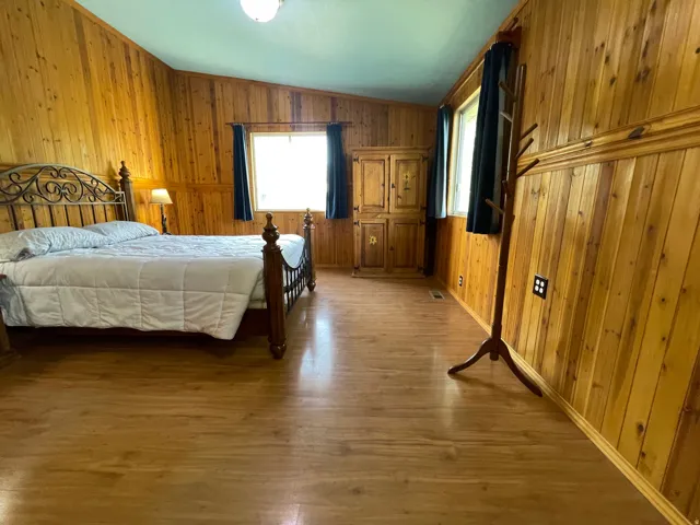Room featuring wood-finish flooring and extensive wood paneling throughout