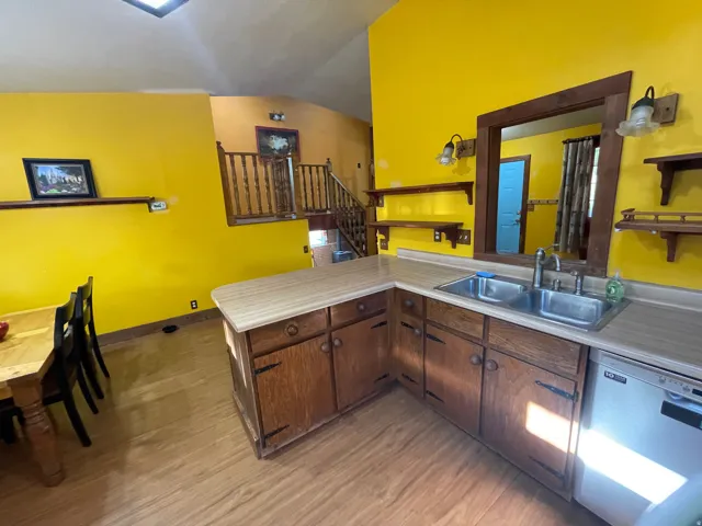 Kitchen area featuring wood-finish flooring, wood cabinetry, and laminate countertops