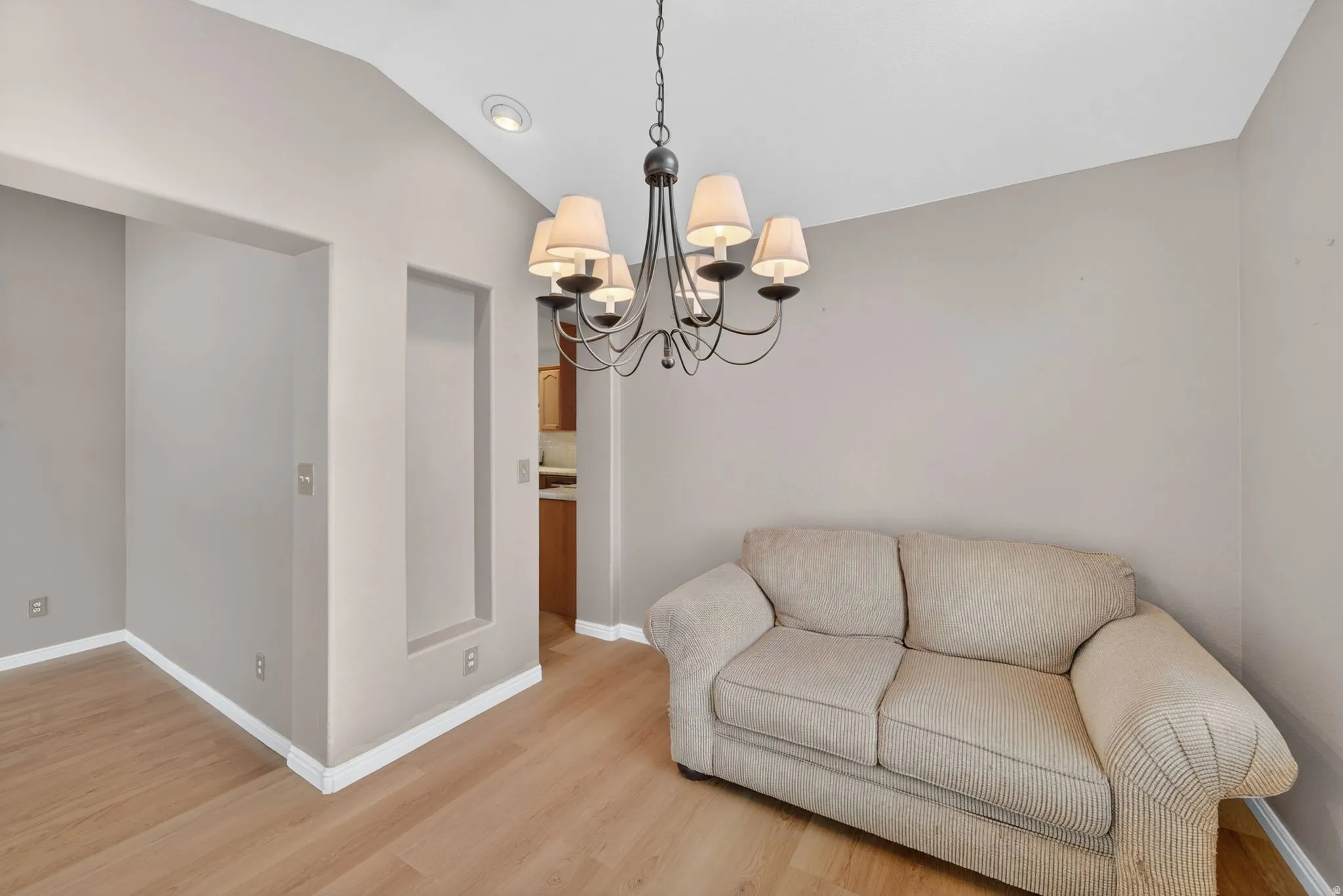 Open area featuring light wood-finish flooring, a vaulted ceiling, and recessed lighting