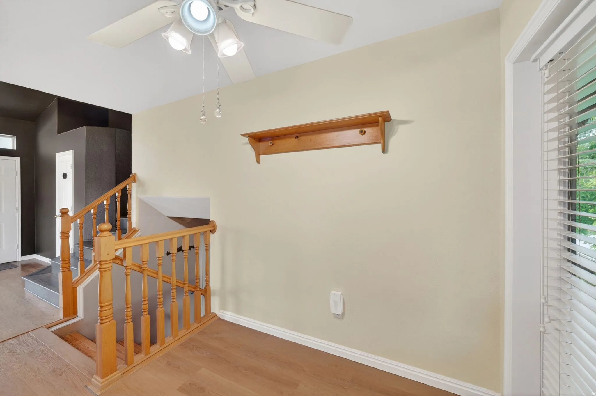 Wood-finish flooring throughout, complemented by a light-toned wall and white trim