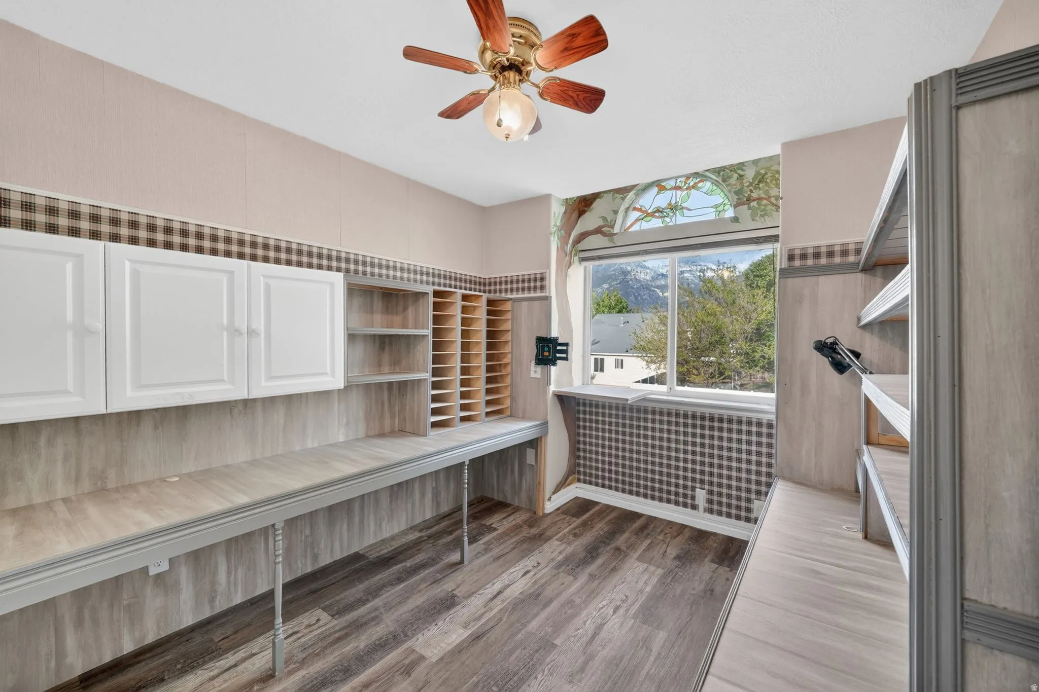 Expansive built-in desk with overhead white cabinetry and integrated shelving