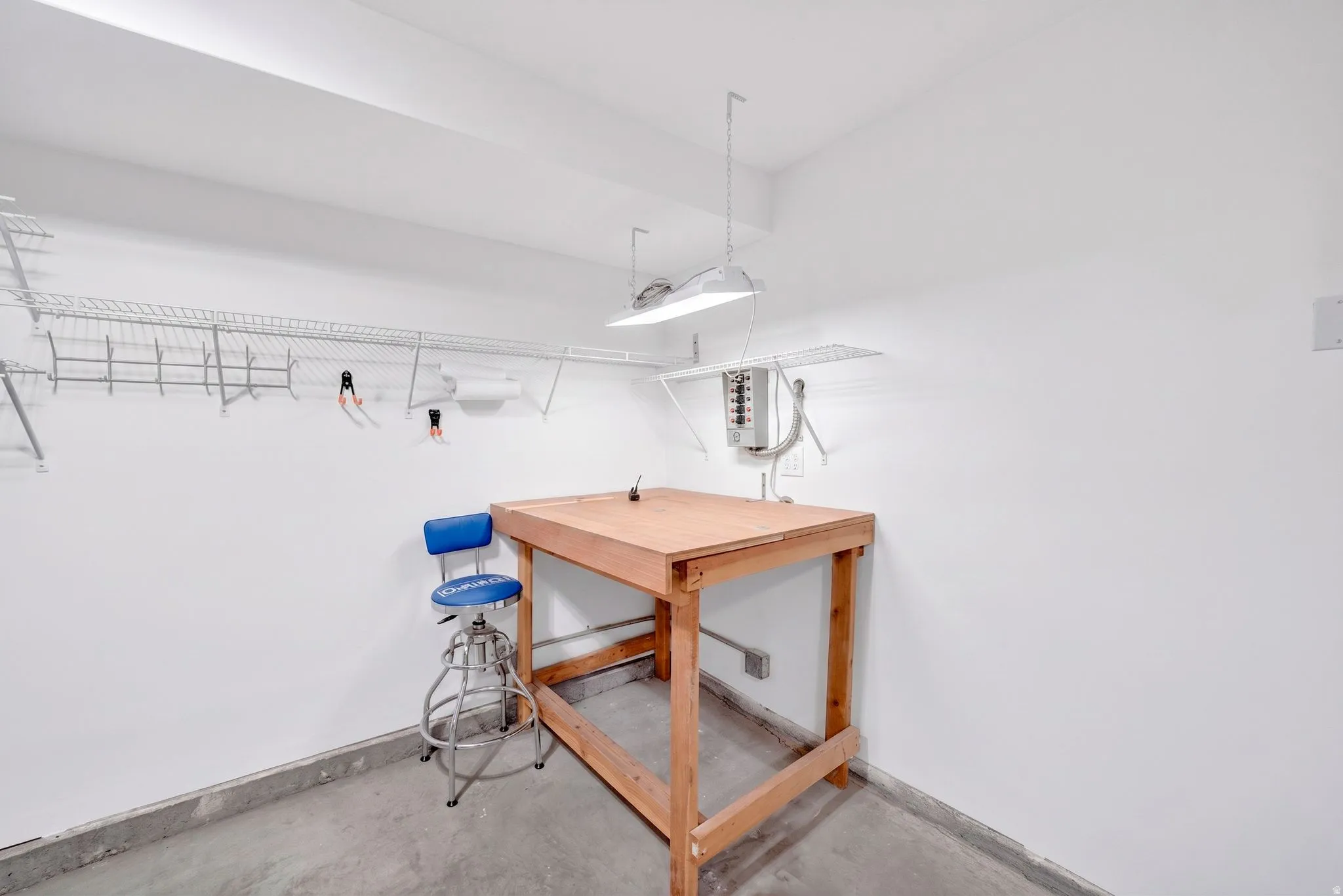Dedicated utility area featuring a wooden workbench and white walls