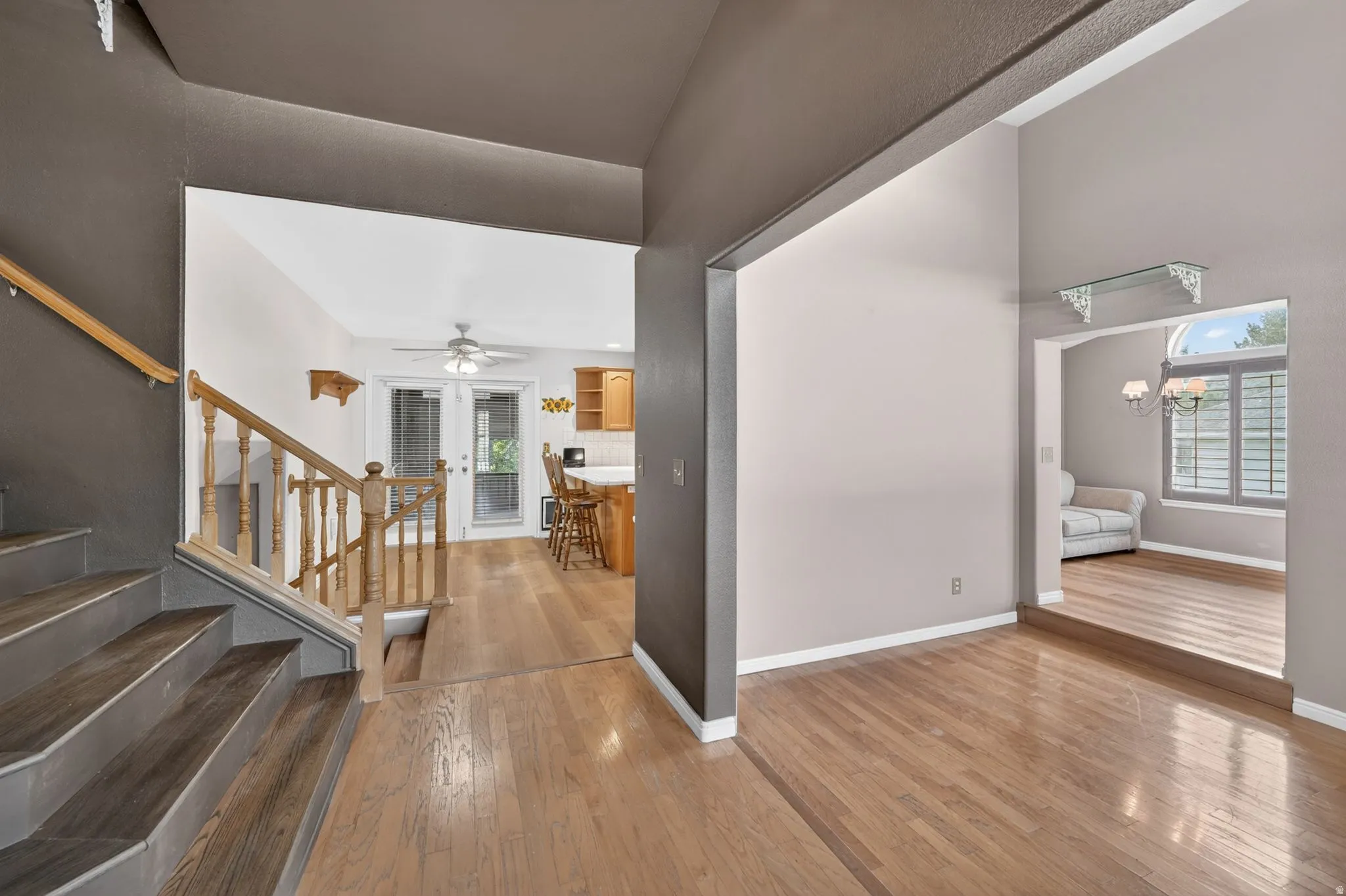 Inviting entryway with wood-finish flooring, a staircase featuring wood banisters, and a spacious archway
