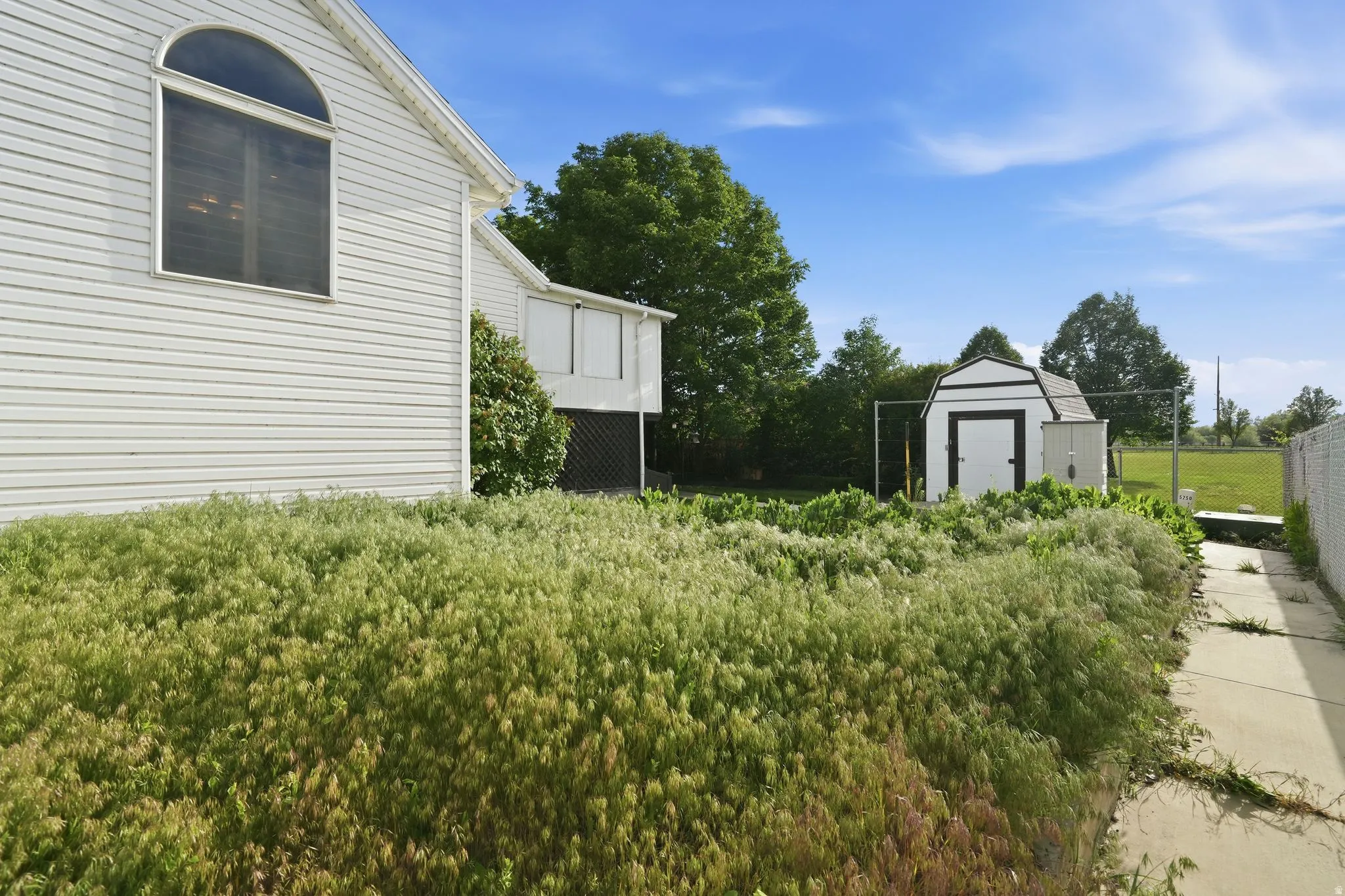 White siding exterior with an arched window