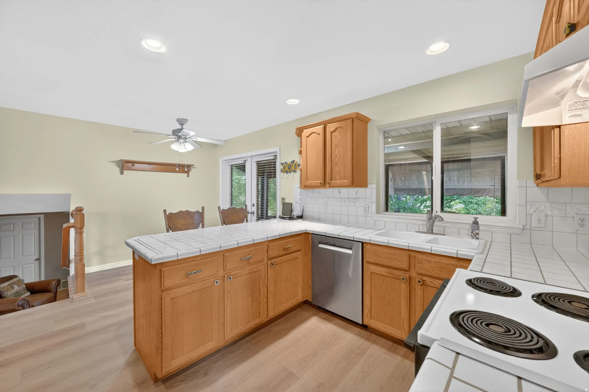 Kitchen featuring wood-finish cabinetry, tile countertops, and a white tile backsplash