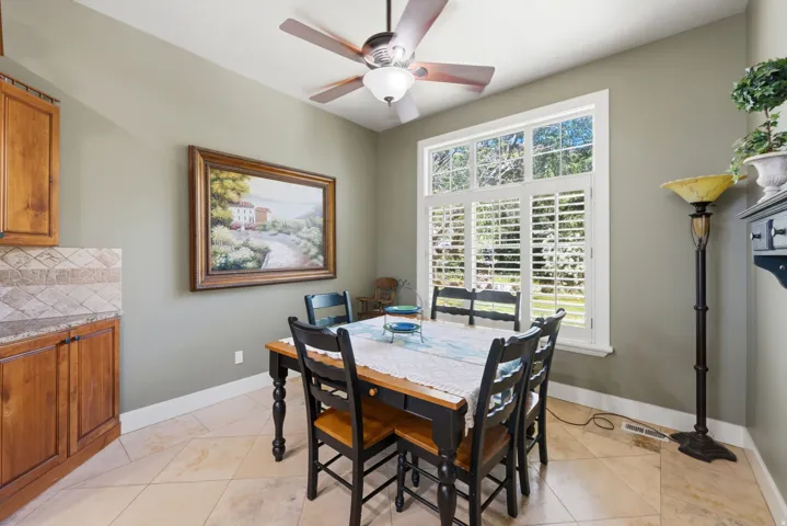 Dining area with a multi-paned window, plantation shutters, and a ceiling fan with integrated lighting