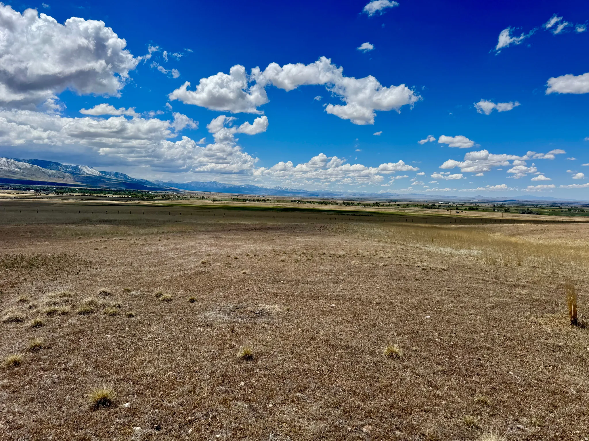Expansive open land with natural grasses, featuring distant mountains and a broad horizon, 19.5 acres north of Fillmore, UT