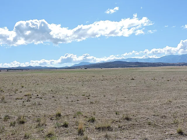 Expansive open land featuring diverse terrain and distant mountain ranges