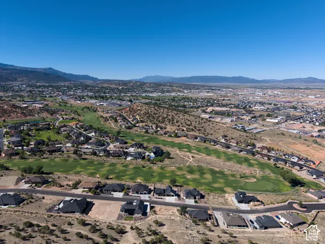Looking South:  Aerial perspective showcasing a residential area with varied rooflines and surrounding natural terrain