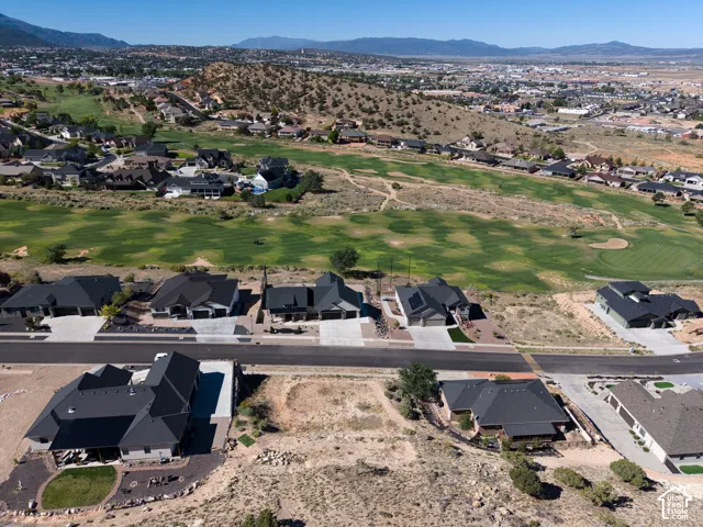 Expansive golf course frontage with surrounding residential development and distant mountain range
