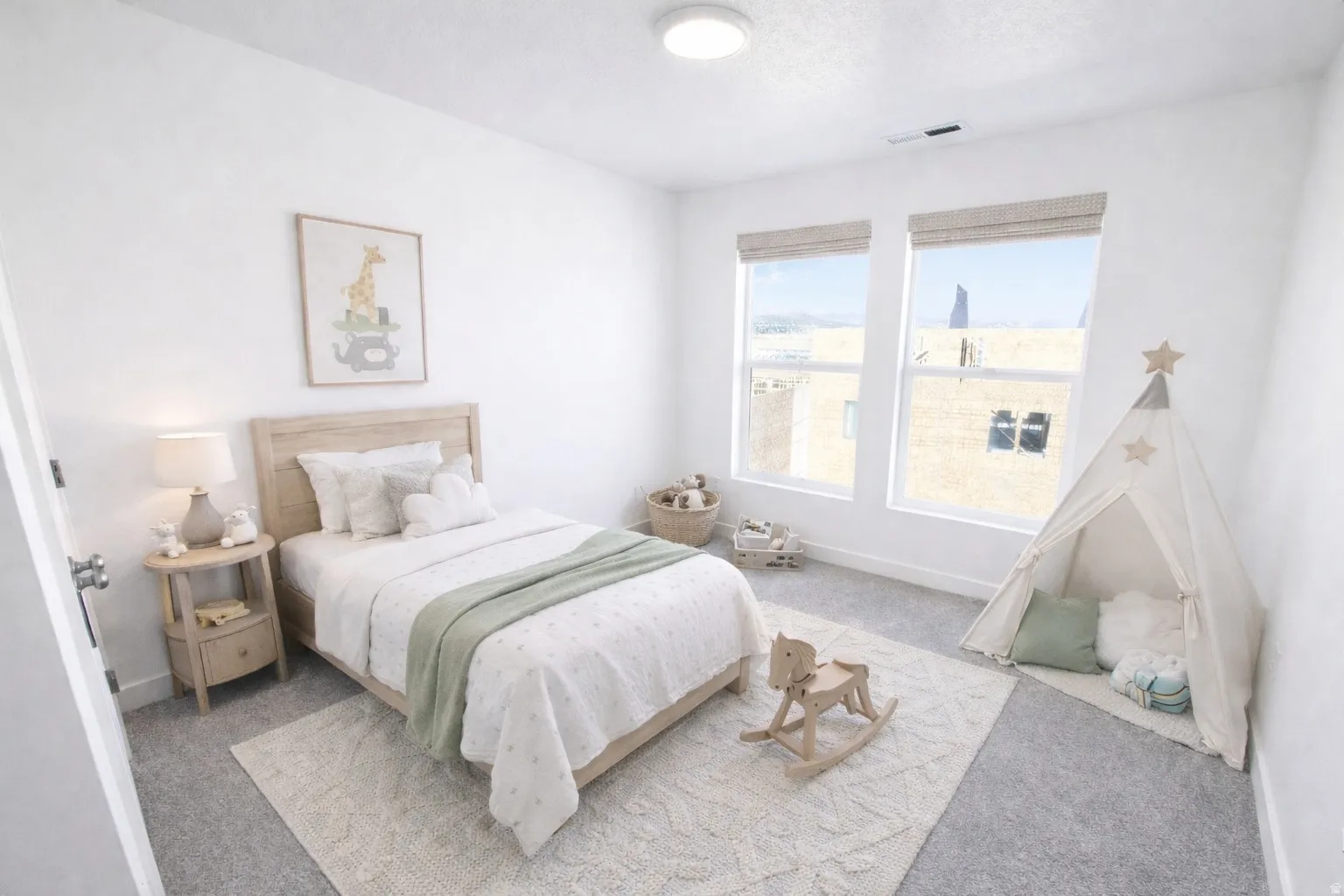 Light-filled bedroom featuring two large windows with woven blinds, neutral carpeting, and a built-in overhead light fixture