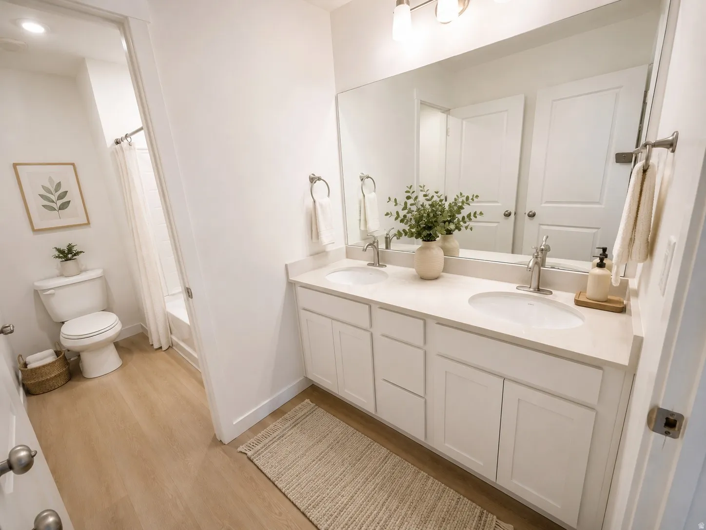 Dual vanity featuring undermount sinks, light-toned countertops, and brushed nickel faucets