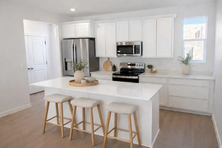 Modern kitchen featuring a central island with countertop seating, white shaker cabinetry, stainless steel appliances, and wood-finish flooring