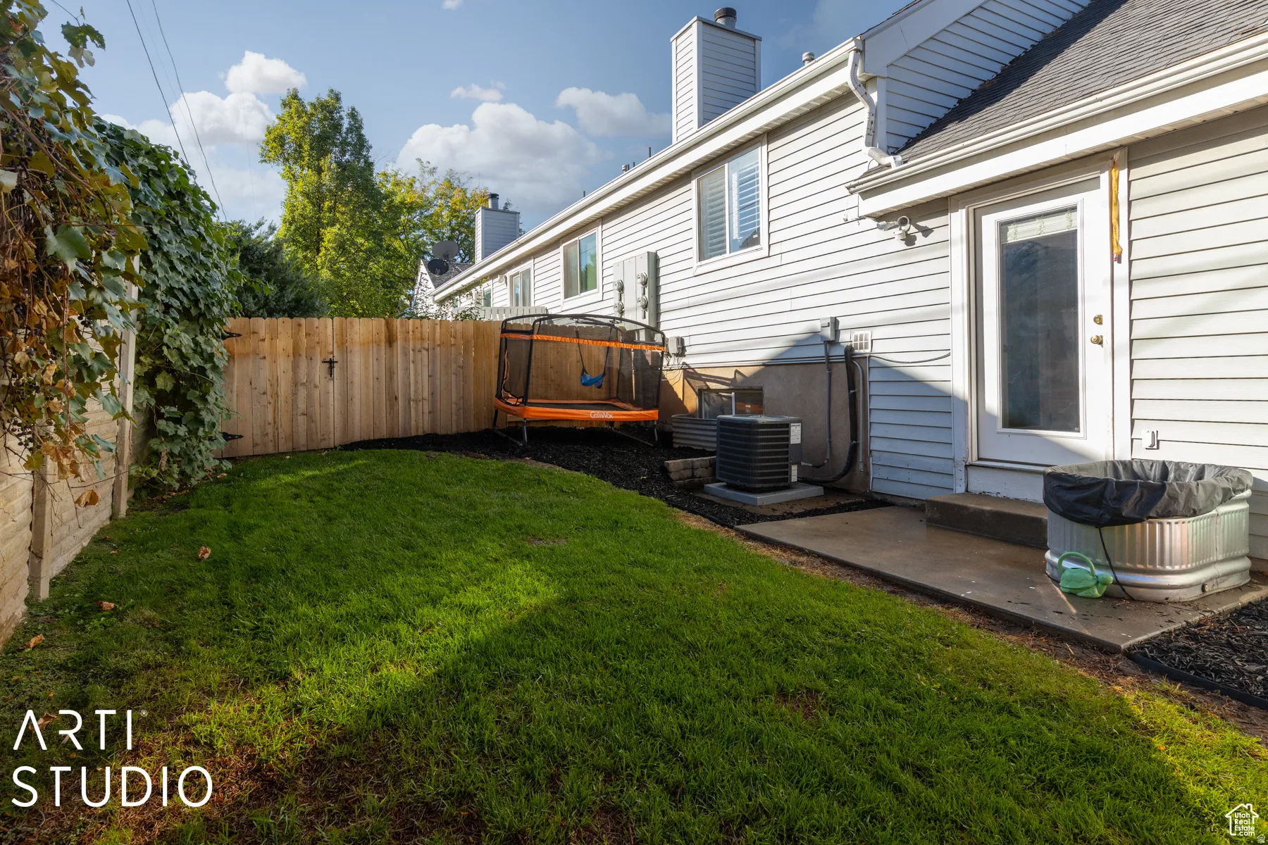 Fenced backyard featuring a manicured lawn, a concrete patio, and a new privacy fence