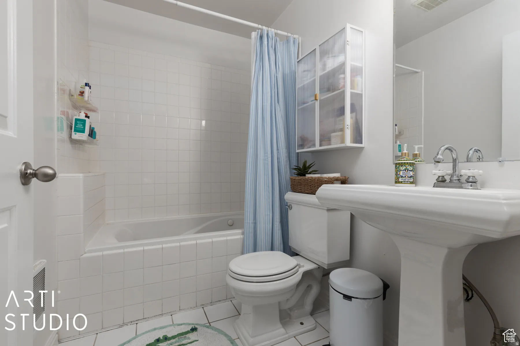 Bathroom featuring a white pedestal sink, chrome fixtures, and a tiled tub-shower combination