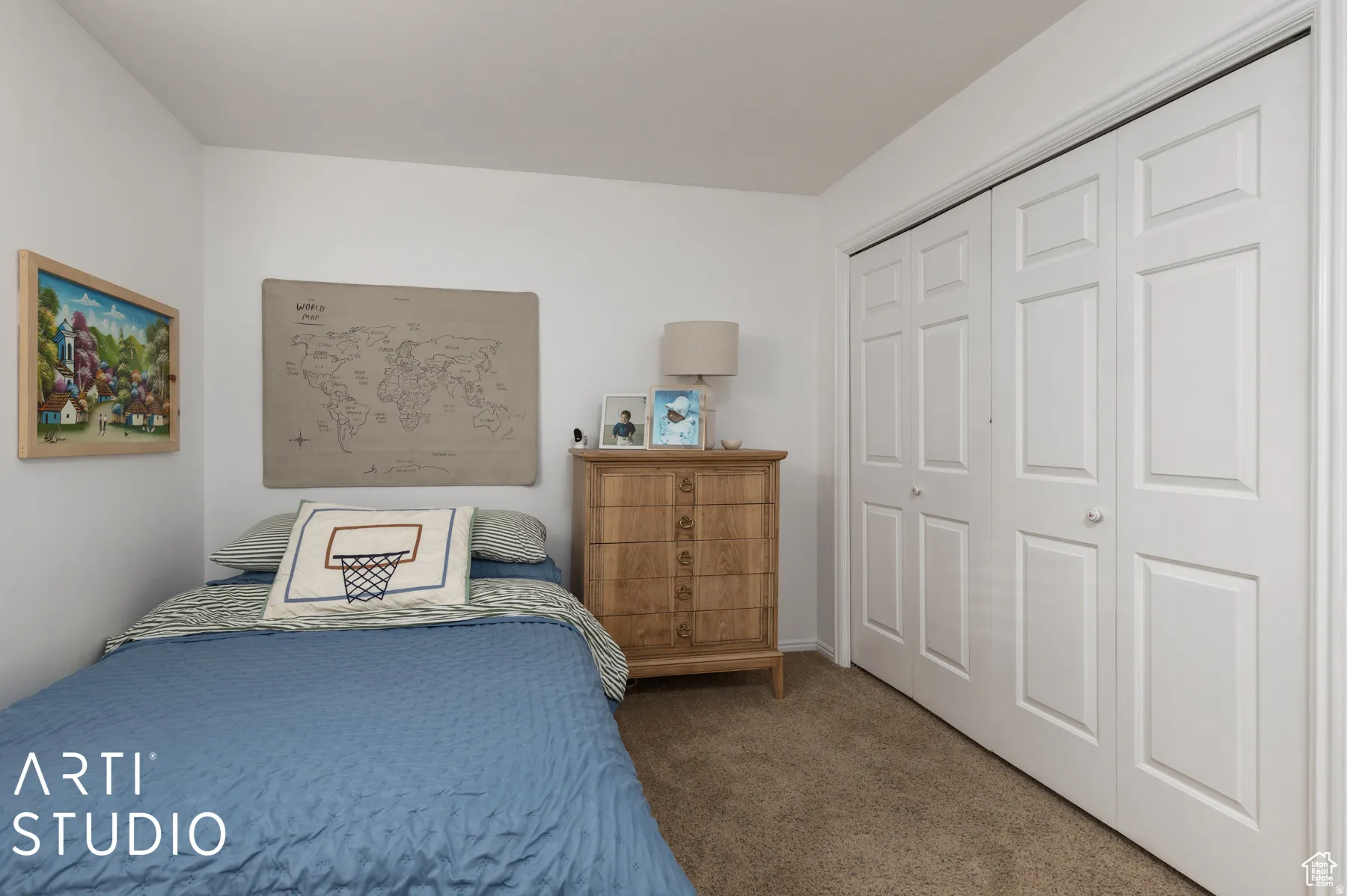Light-filled room featuring white walls, textured carpeting, and a built-in bifold closet with panel doors