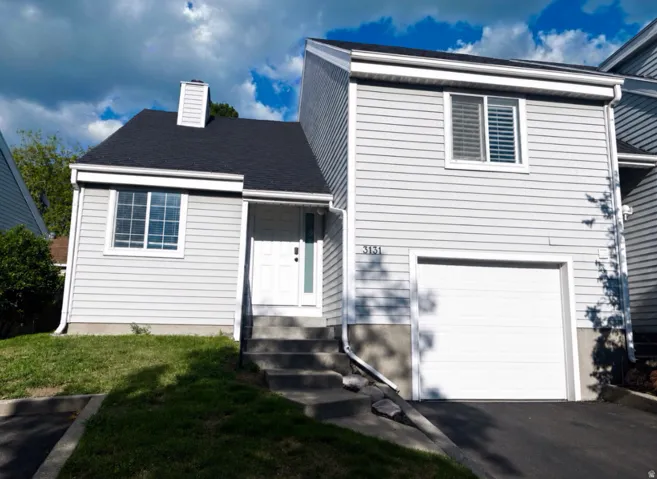 Light gray siding exterior with a dark shingle roof