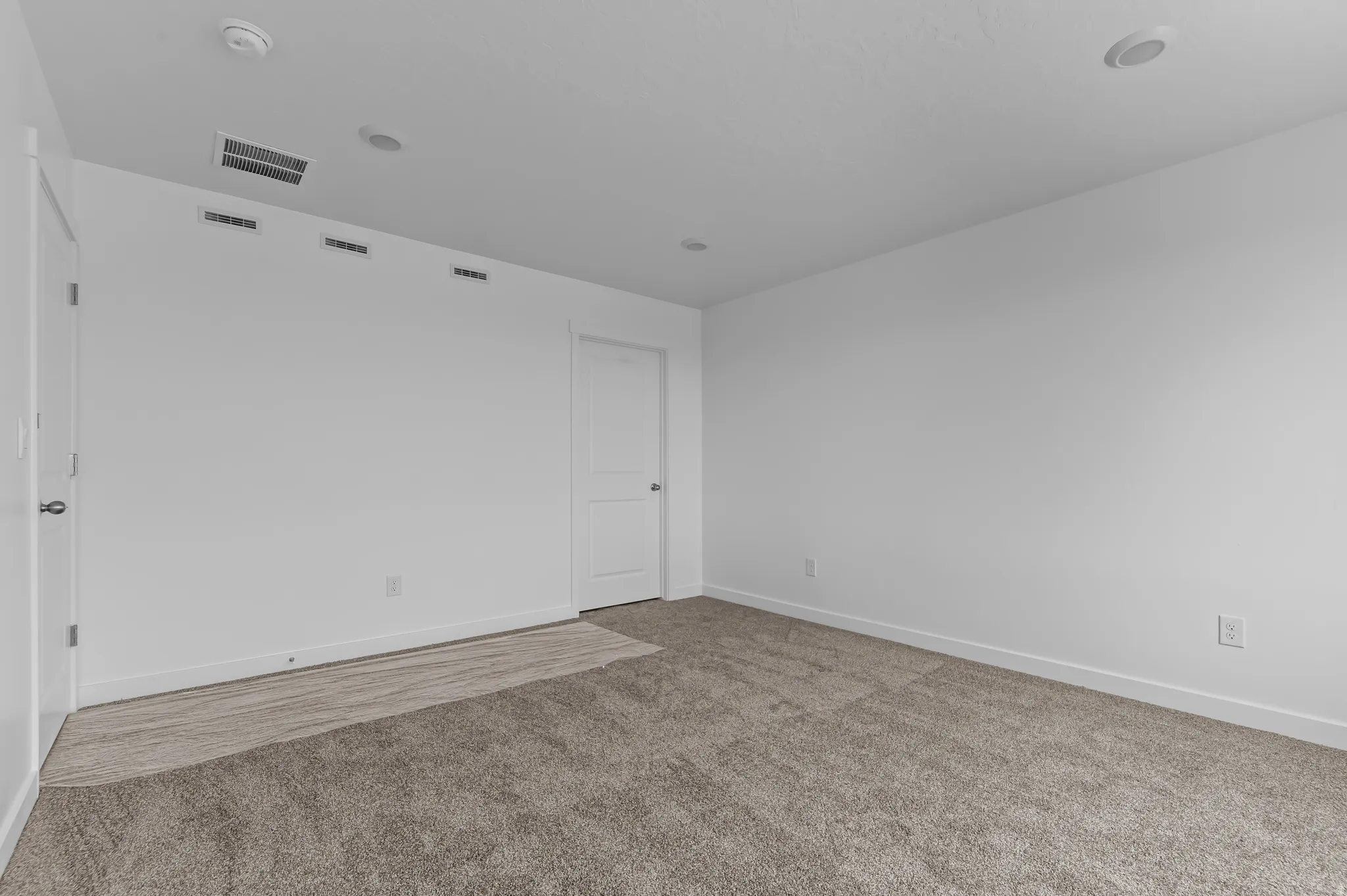 Spacious room featuring neutral carpeting and white walls