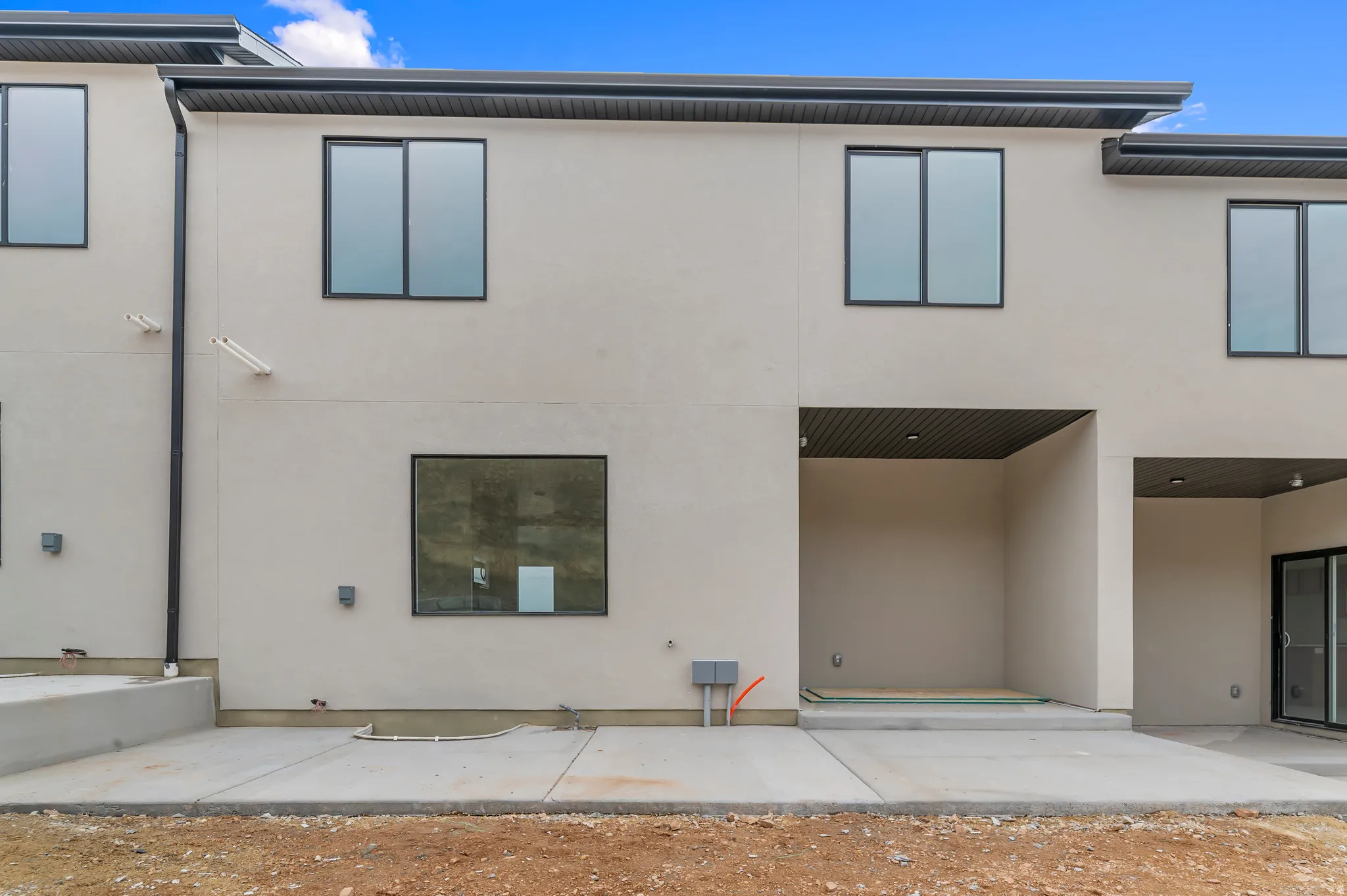 Neutral-toned stucco exterior with black-framed windows