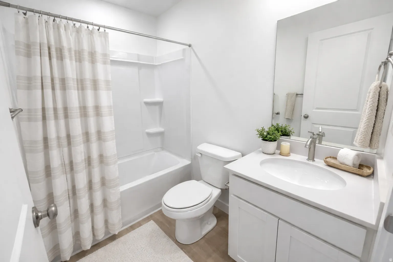 Bathroom featuring a white vanity with an integrated sink, brushed nickel faucet, and a large wall-mounted mirror