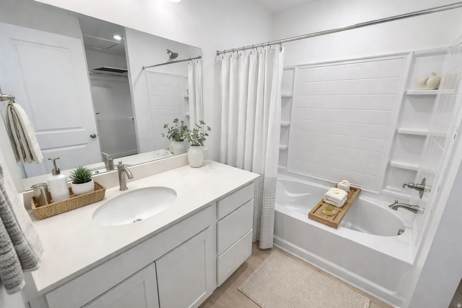 Contemporary bathroom featuring a white vanity with an undermount sink and a light-toned countertop