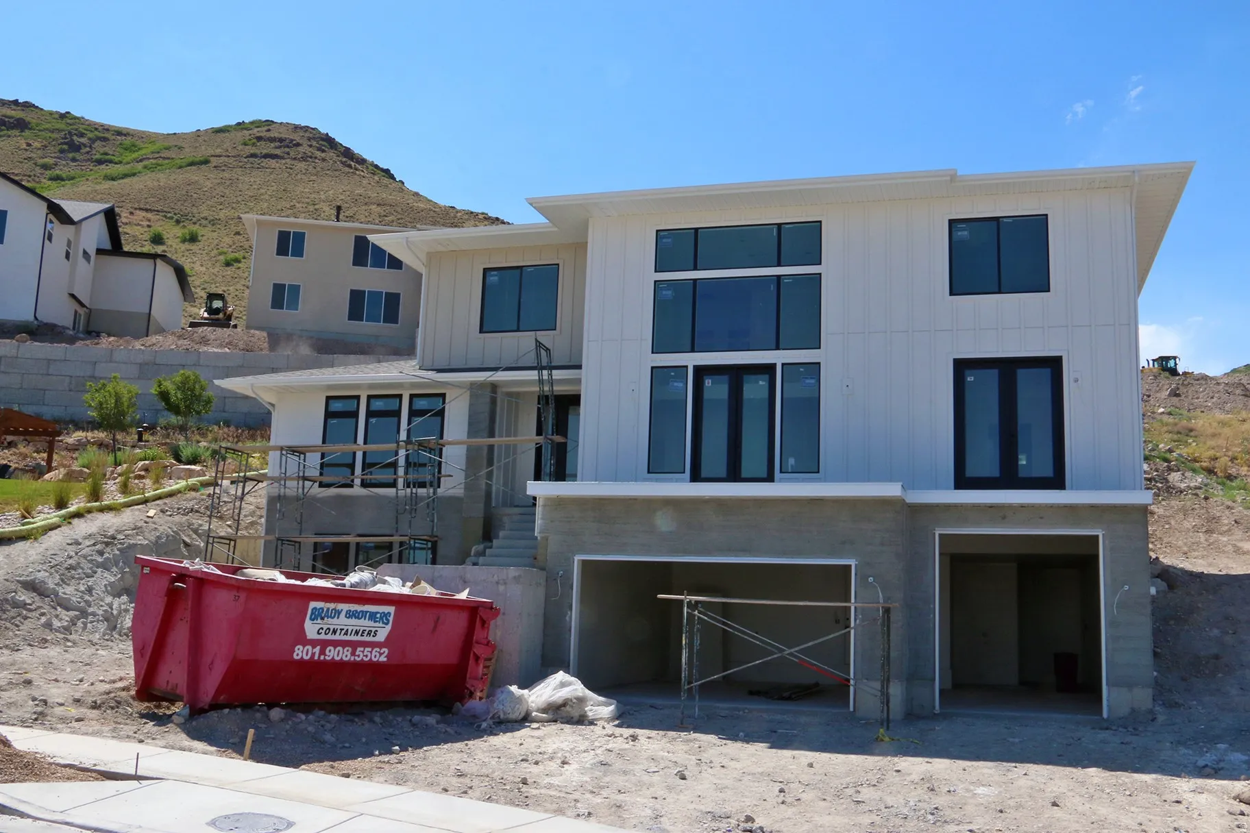 Modern architectural residence with a white vertical siding exterior and a multi-level design