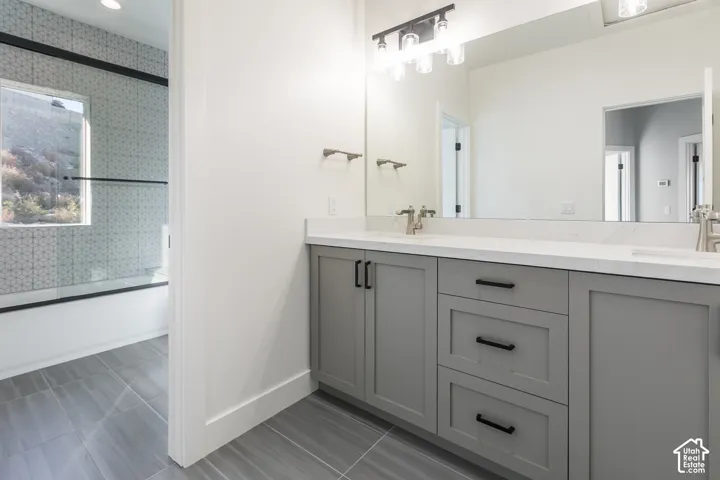 Dual vanity with light gray cabinetry, white countertops, and brushed nickel fixtures