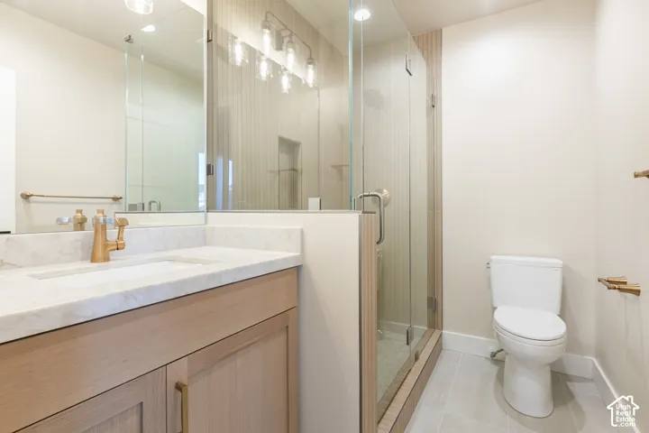 Light wood-finish vanity with a single basin sink and a brass-tone faucet