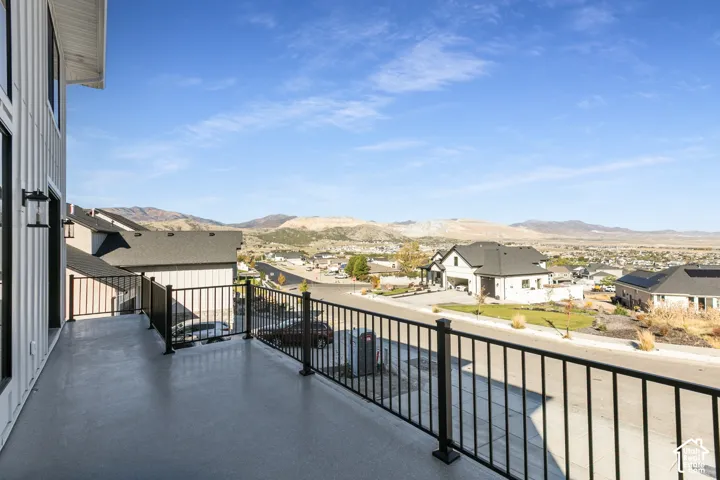 Exterior deck with black metal railings, overlooking a neighborhood with distant mountains