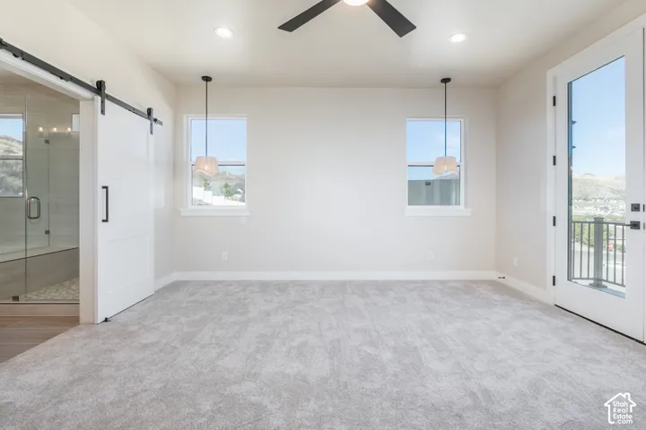 Carpeted room with a ceiling fan, recessed lighting, and two pendant lights