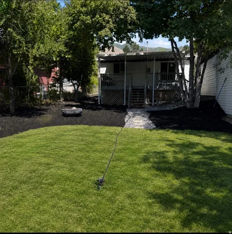 Expansive green lawn with a stone pathway leading to a rear deck