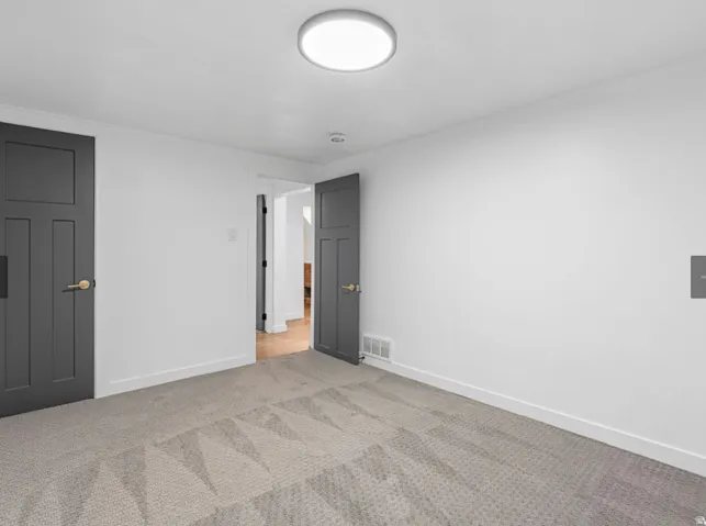 White-painted walls complement the light-colored carpet flooring