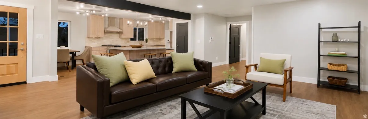 Open-concept living space featuring wood-finish flooring, recessed lighting, and a prominent black beam