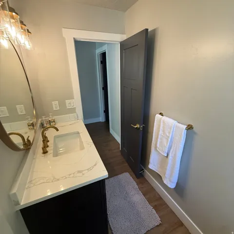 Vanity featuring a white countertop with grey veining, undermount sink, and brass-tone faucet